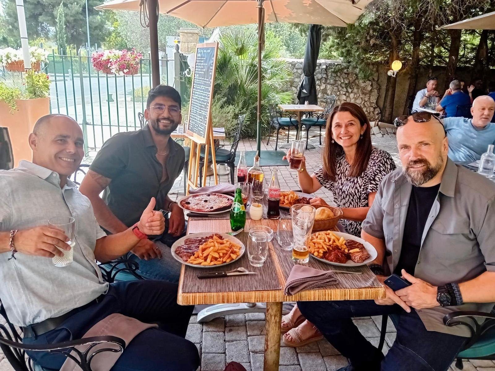 Manan Mehta at an outdoor restaurant table with four clients
