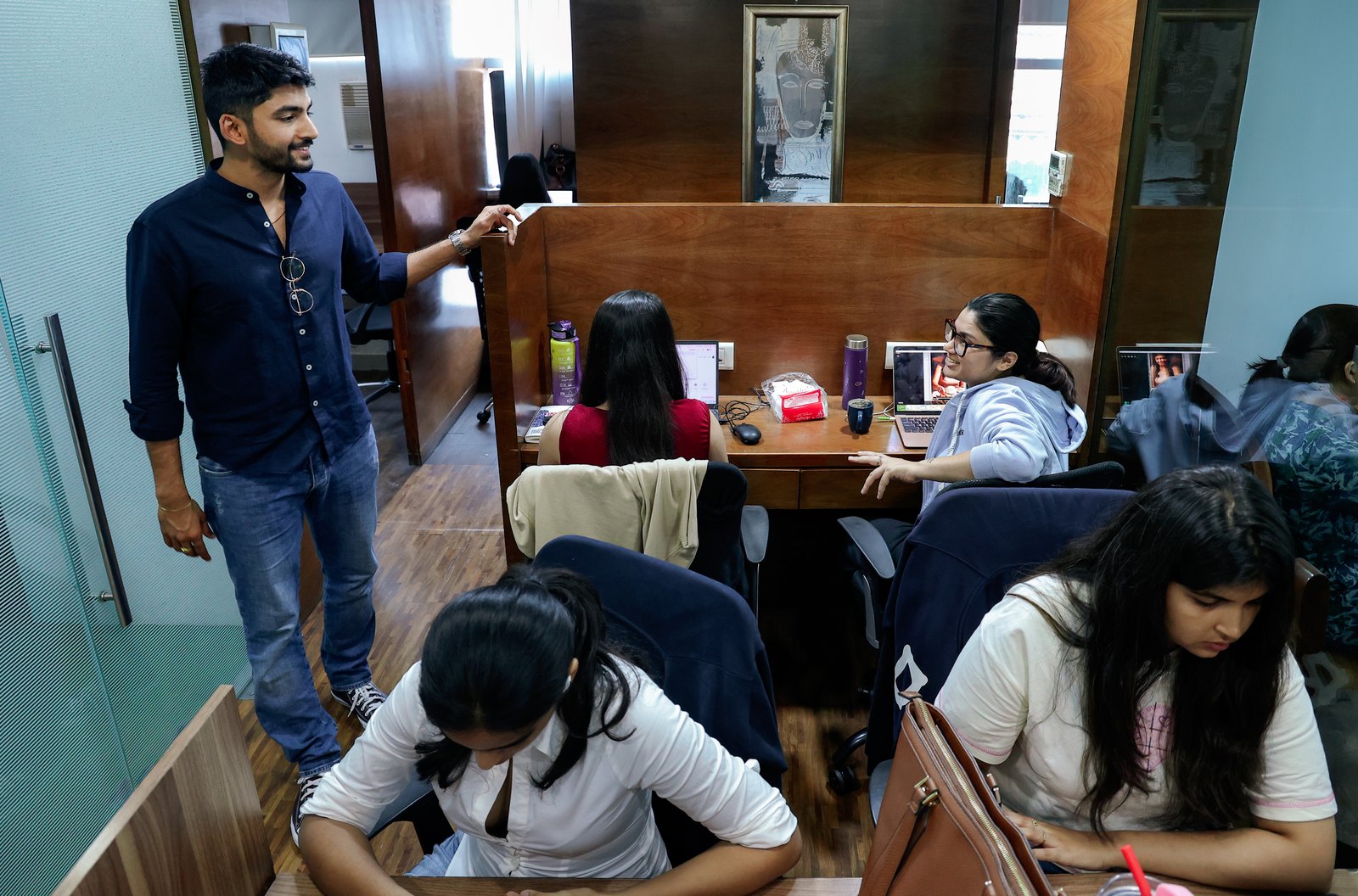 Manan Mehta standing in the MarketinCrew office in Mumbai while the team works at their desks